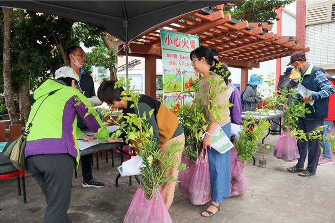 林保署台东分署13日在绿岛举办赠苗及防火宣导活动，民眾排队观看防火看板并领取树苗。（林保署台东分署提供／蔡旻妤台东传真）