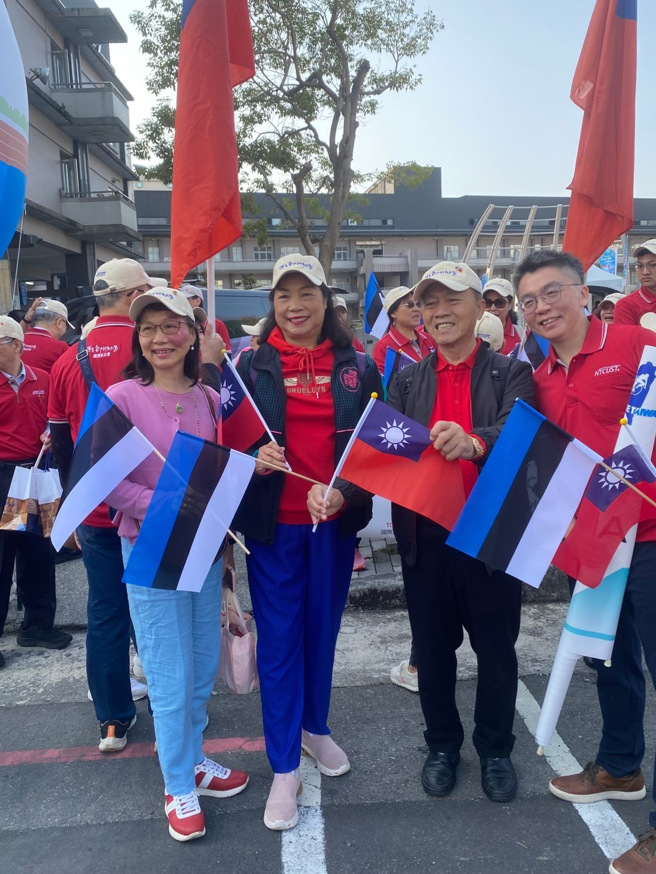 臺中科技大學國貿系系友會成員手持中華民國（台灣）及愛沙尼亞國旗為兩國自由車隊加油。（駐拉脫維亞代表處提供）