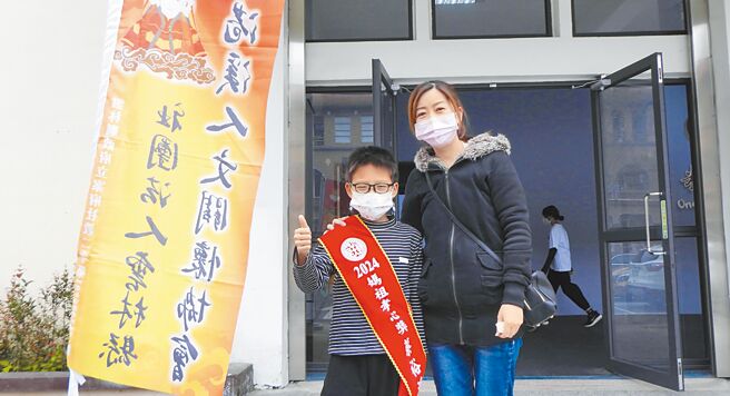 去年不幸殉職的花蓮縣消防局消防分隊長蔡璽鈞大兒子蔡裕鴻（左），在家中遭逢巨變的1年期間，主動幫忙母親詹璽蓁（右）分擔家事，12日獲得雲林北港朝天宮「孝心獎」肯定。（羅亦晽攝）