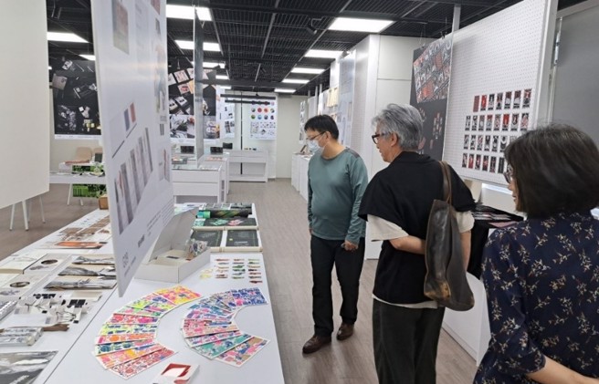 岭东科大视传系黄庭超副教授(左)为常一飞创意长(中)解说作品创作理念。（图／时报金犊奖提供）