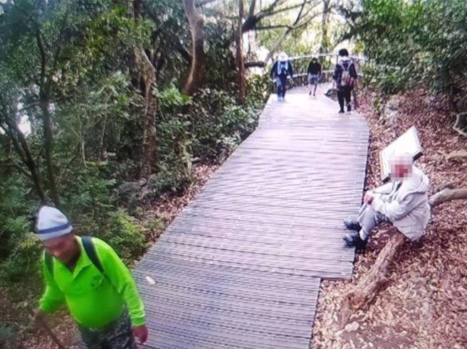 老翁14日一早独自一人拄着拐杖上山，9点多时走到北寿山龙泉寺登山口计数器旁，监视器清楚拍下老翁在路旁树干停留休息的模样。（自管处提供／袁庭尧高雄传真）