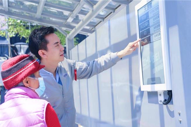 竹北市公所試辦太陽能電子紙智慧站牌，15日正式開通，在天后宮站、竹北市公所兩座車站試行1年，市長鄭朝方（右）向民眾解說乘車資訊。（竹北市公所提供／邱立雅竹縣傳真）