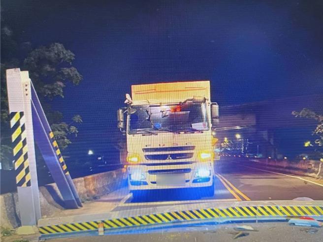 桃園市蘆竹區油管路二段山腳橋前今15日清晨4時53分發生大貨車撞毀2.5公尺限高門架，造成門架掉落橫躺於路中阻礙車輛通行，蘆竹分局交通分隊及外社派出所獲報後趕往現場進行交通管制及疏導，並通知相關單位到場處置、移除，初步調查大貨車駕駛疑似因路況不熟誤闖該路段，因車輛過高而撞倒限高門架，現場無人員傷亡。（翻攝照片）