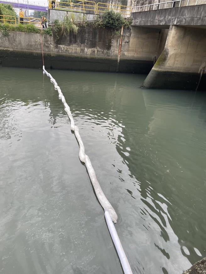 玉成抽水站周边现油污异味，台北市环保局于下游处布设吸油棉索，防止油污扩散至基隆河。(黄敬文翻摄)