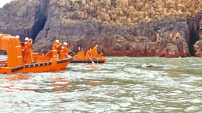 陸籍漁船「閩龍漁61222」14日清晨進入金門東碇島禁限制水域因觸礁沉船，兩岸分別派艦艇聯合救援，共救起4人，其中2人罹難，尚有2人失蹤。白色頭盔為陸方搜救人員。（海巡署提供／于家麒金門傳真）