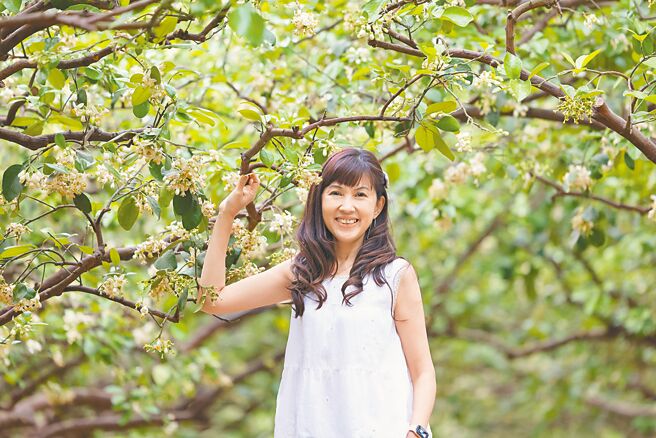 目前進入柚花盛開期，今年受氣候涼冷影響，麻豆區柚花開花速度減緩，比往年少了3成。圖為麻豆區農會總幹事孫慈敏行銷當地柚花美景。（麻豆區農會提供／寶智華台南傳真）