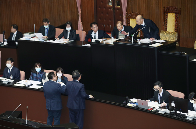 立法院15日院會輪到經濟組立委質詢行政院長陳建仁，由於民進黨立委陳亭妃改書面質詢，主持的院長韓國瑜（右上）一路唱名，後續表訂質詢的立委未及到場，韓院長隨後宣布休息，趕來的立委洪申翰、邱志偉（左下）上前抗議，韓揮手安撫。（資料照）