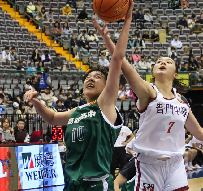 阳明高中魏诗芸（左）和普门中学李郁慈（右）争抢球权。（罗永铭摄）