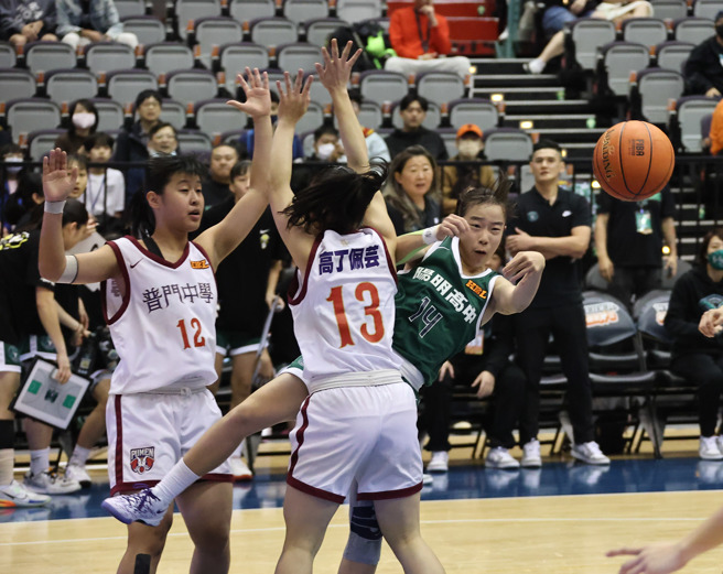 阳明高中苏衡（右）从普门中学防守球员中努力传球给队友。（罗永铭摄）
