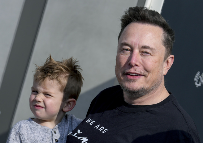 電動車品牌特斯拉（Tesla）老闆馬斯克13日到德國柏林附近巡視廠區。懷中男孩據說是他與上一任伴侶格萊姆斯生的兒子X AE A-XII。（美聯社）