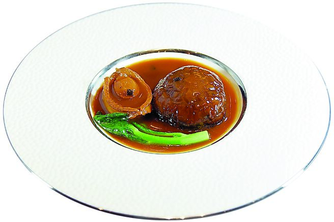 〈陈年菜脯鲍鱼扣花菇〉以30年客家老菜脯丁，与煨了四小时的鲜鲍、焖煮二小时的花菇一起，再焖煮二小时提味。图／姚舜