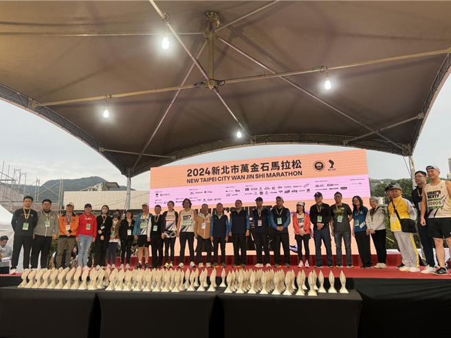 2024新北市萬金石馬拉松17日舉行，新北市長侯友宜與工作人員合影。（張鎧乙攝）