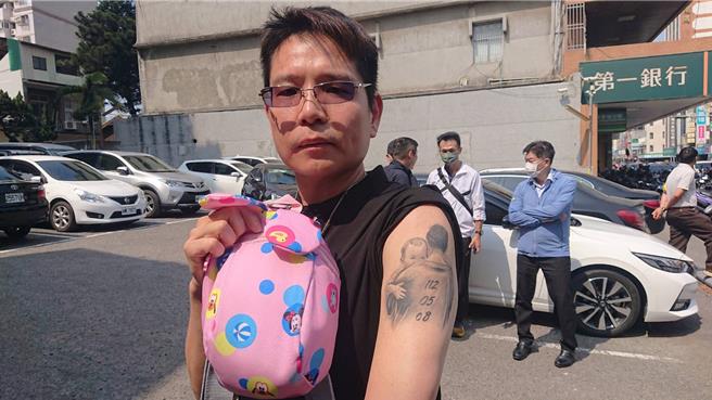 台南市人本交通促进协会理事长余志祥在女儿发生事故后暴瘦10公斤，17日带着女儿生前的包包，秀出1月才刚去刺下拥抱女儿且有事故发生日期的手臂刺青，直呼女儿给自己力量，站出来对抗恶法。（程炳璋摄）