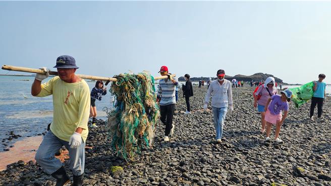 500人17日春季淨灘準備迎遊客，讓澎湖摩西分海變乾淨了。圖為志工沿著摩西分海的海底步道，將從烈嶼海岸線清起的廢棄漁網抬上岸。（許逸民攝）