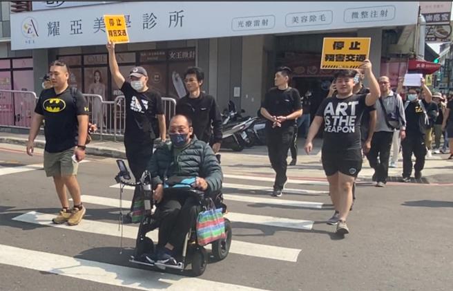 行人零死亡推动联盟17日展开串连路口快闪行动，中市于台中车站附近集结百余人，并在復兴路四段游行，沿途高喊口号，队伍中有身障人士乘坐轮椅、年轻家长推婴儿车参与。（陈淑芬摄）