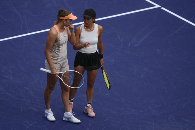 谢淑薇（右）、梅腾丝在场上讨论策略。（美联社）