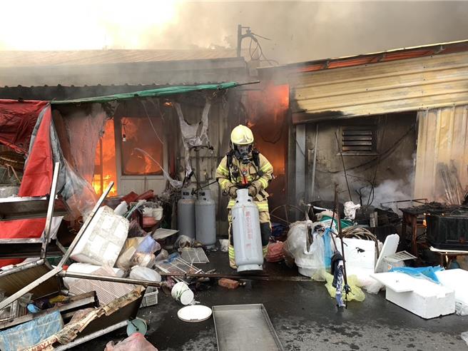 消防人員將瓦斯鋼瓶趕快移出、遠離火場。（讀者提供／張毓翎台南傳真）