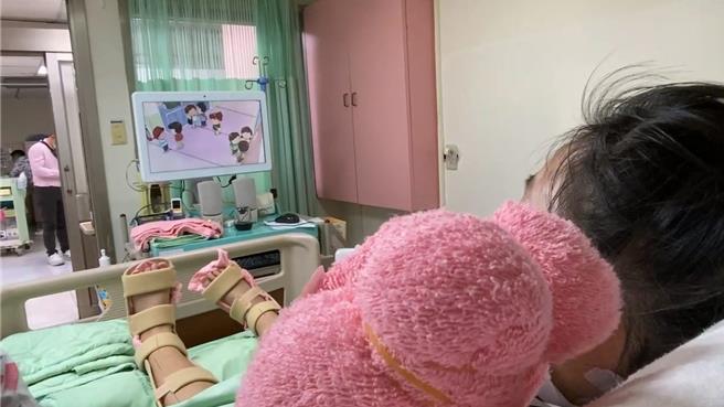 仍在彰化市秀傳醫院加護病房的陳姓姊姊18日在病床上觀看卡通影片，她的狀況逐日好轉中。（秀傳醫院提供／孫英哲彰化傳真）