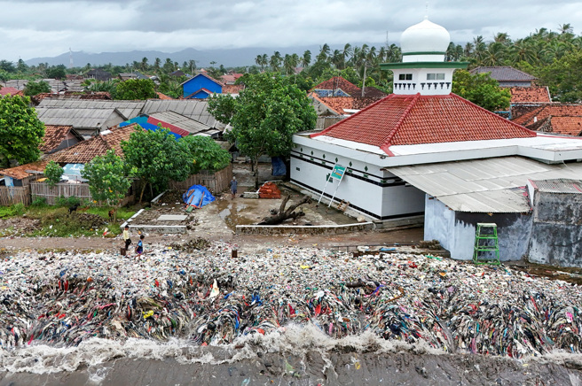 大批垃圾沖上印尼特魯克（Teluk）小漁村。（圖／路透社）