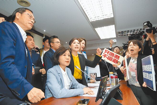 立法院18日邀请卫福部等单位就「社会安全网推动情形及策进作为」专题报告，会议一开始，蓝、绿立委发生争执，民进党立委举标语抗议，要求国民党召委王育敏（前左二）利益迴避、另推派主席；而国民党立委则上台声援。（刘宗龙摄）