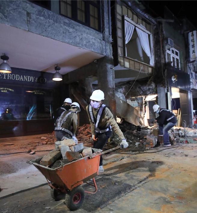 工作人員徒手搬運瓦礫，希望能盡快恢復交通。（黃世麒攝）