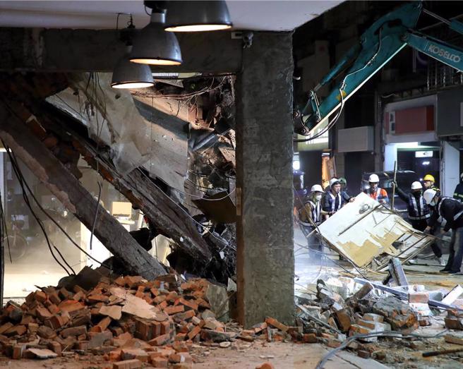 老宅的2樓樓地板整個塌陷，壓住多輛停在騎樓的機車，重機具進場拆除。（黃世麒攝）