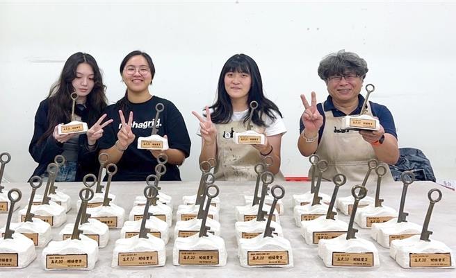 国立高雄大学将于23日举行24周年校庆。校方委请工艺与创意设计学系系主任陈冠勋（右）带领学生制作《解码大地生机》陶瓷奖座。（高雄大学提供／林瑞益高雄传真）