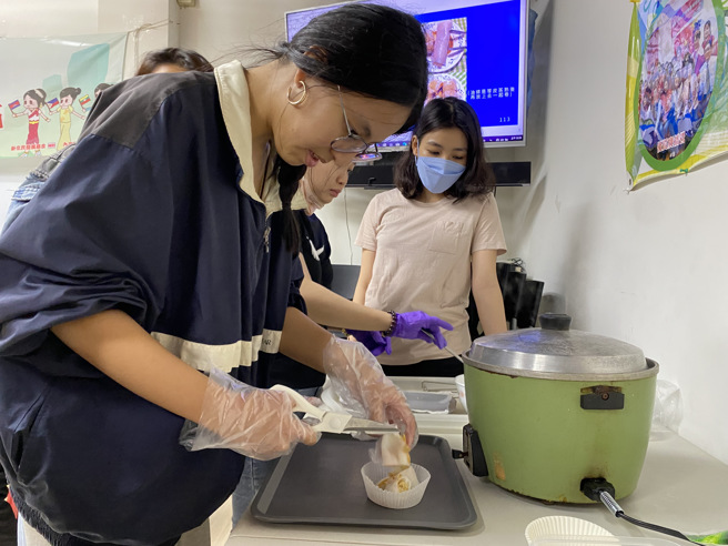 新二代钰静以剪刀将制作好的港式肠粉剪成好几节，方便和大家分享她的成品。(戴志扬翻摄)