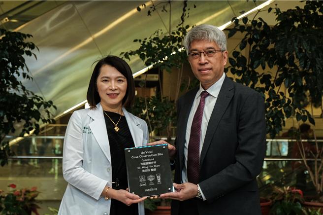 达文西机器手臂制造商直觉台湾分公司副总裁杨继盛（右），20日颁给认证奖牌给中医大新竹附医外科部长沈名吟（左），沈也成为全台首位大肠直肠外科达文西机器手臂手术观摩中心的女医师，可进行达文西手术教学。（罗浚滨摄）