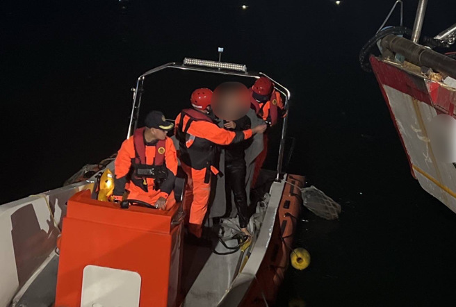 醉男無法自行攀爬上岸，安檢所港巡人員士官長黃種益等3員，立即啟動救援機制，並駕駛救生艇趕往救援。(戴志揚翻攝)