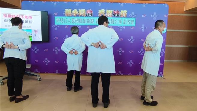 江振豪医师教双手伸举至背部腰间，自我检测。（廖素慧摄）