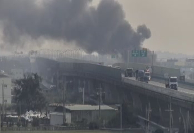 起火燃燒的塑膠工廠緊鄰台61快速道路，濃黑煙直竄天際。（翻攝國道1968）