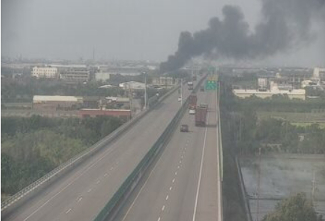 起火燃燒的塑膠工廠緊鄰台61快速道路，濃黑煙直竄天際。（翻攝國道1968）