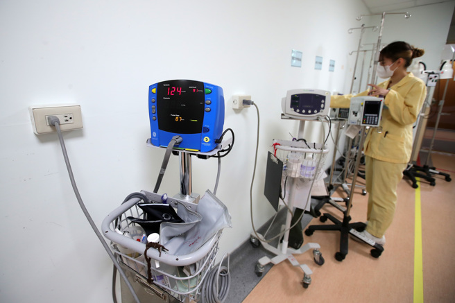 新北市某区域医院内，护理人员正为整排的血压机等医疗仪器充电。（黄世麒摄）