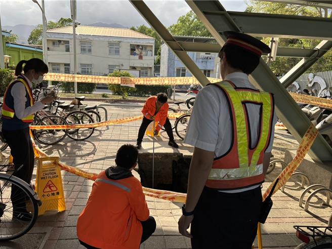 花莲瑞穗火车站后站停车场突然出现宽2公尺坑洞，深度约2.5公尺，台铁人员紧急在现场拉起封锁线。（民眾提供）