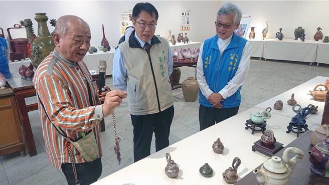 台南市长黄伟哲（中）22日参访祀典兴济宫内陶瓷展览，与陶艺家翁国祯（左）研究陶壶作品。（程炳璋摄）
