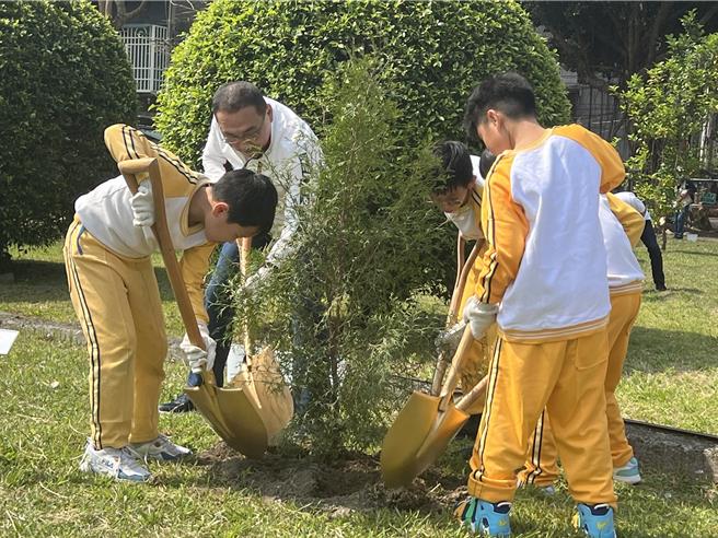 侯友宜带领学童一起种下肖楠树。（王扬杰摄）