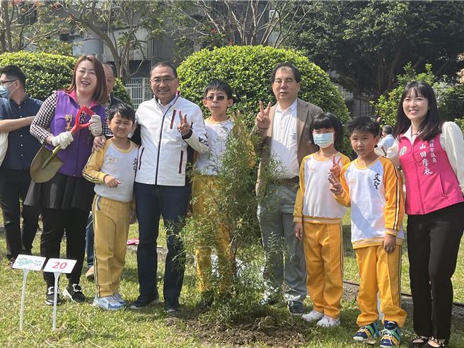 侯友宜带领学童一起种下肖楠树。（王扬杰摄）