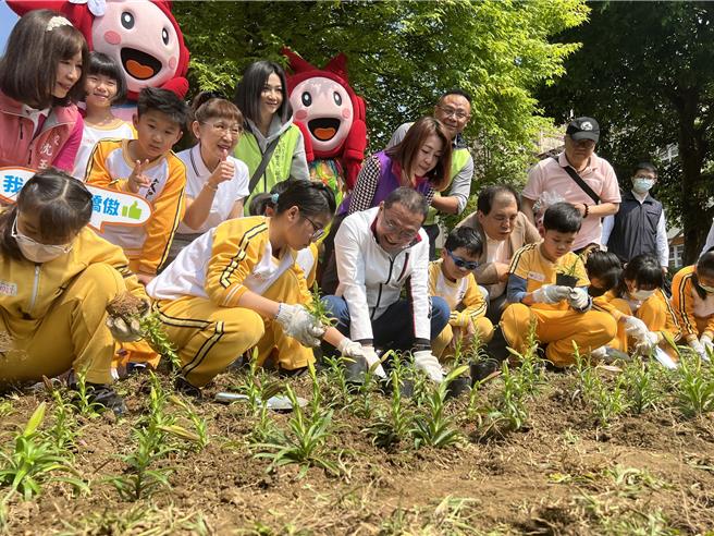 侯友宜带领学童一起种下台湾百合。（王扬杰摄）