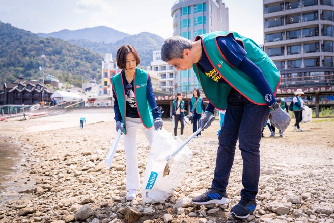 台湾人寿谢壮堃代理总经理（右一）在日月潭捡拾废弃物，以行动维护永续环境。(图/台湾人寿提供)