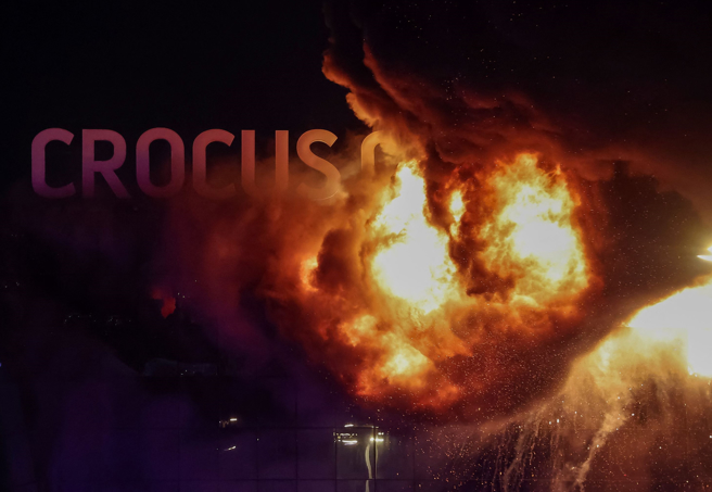 俄罗斯「克洛库斯音乐厅」（Crocus City Hall）参加音乐会的群眾22日遇袭后，会场冒出熊熊大火。（路透）