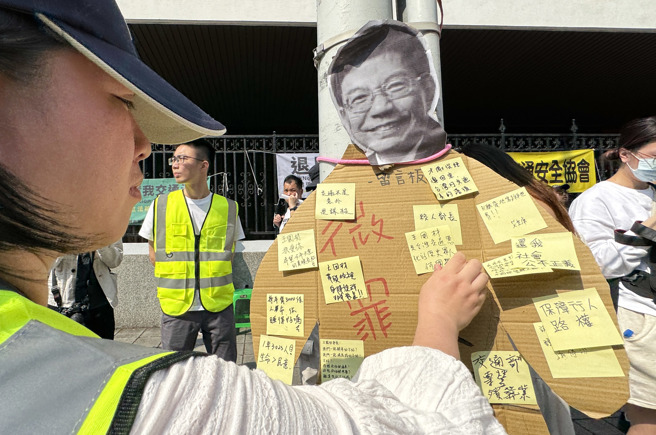 「行人零死亡推動聯盟」等路權團體23日在立法院外舉辦「抗議道交條例惡法」集會遊行活動，並在交通部長王國材人像背板上留言，要求退回微罪不記點、微罪不檢舉措施。（姚志平攝）