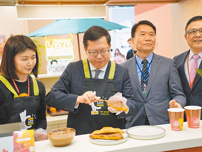 为提供民眾更多创业机会，台湾连锁加盟促进协会22日起至25日在台北世贸一馆举办「2024台北国际连锁加盟大展─春季展」，行政院副院长郑文灿（左二）也下场体验一日早餐店员。（黄敬文摄）