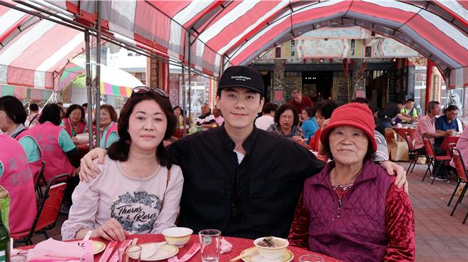 《她和她的她》男主角李程彬（中）夺金钟视帝回乡办桌谢乡亲，与母亲（左）和阿嬷（右）温馨合影。（东旭九翔娱乐）