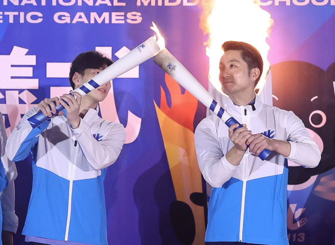 台北市長蔣萬安（右）24日出席全國中等學校運動會聖火啟動儀式，並傳遞聖火給擔任本屆賽會代言人運動員王冠閎（左）。（陳俊吉攝）