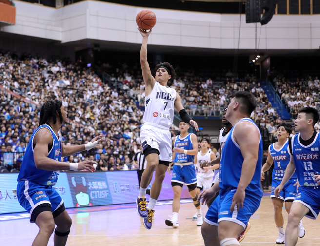 112學年度UBA大專籃球聯賽公開男一級冠軍戰24日在台北小巨蛋開打，政治大學游艾喆（中）突破健行科大球員的防守上籃。（黃世麒攝）