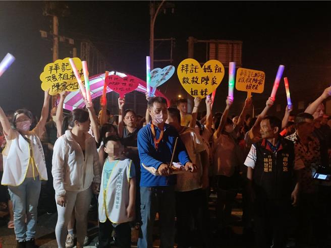 阿公、姑婆带着弟弟在车祸路口等待妈祖銮轿赐福。（陈淑娥摄）