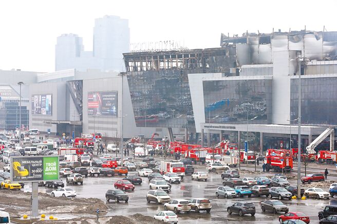 莫斯科緊急救災單位的車輛，停在燃燒的番紅花音樂廳附近。（路透）