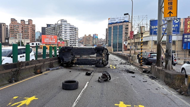 白色賓士撞擊分隔島後側翻在車道上。（新北市三重警分局提供／呂健豪新北傳真）
