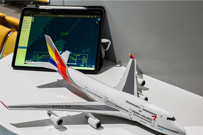 韩亚航空最后一架747型客机25日执行最后载客飞行，韩亚航空也特别在韩国仁川机场及桃园国际机场两地都举办欢送仪式，一位韩国航空迷特别提前来台湾玩几天，还带了韩亚航747模型机在候机室接机，也透过平版电脑随时追踪航班资讯，很期待这一趟飞行。（陈麒全摄）